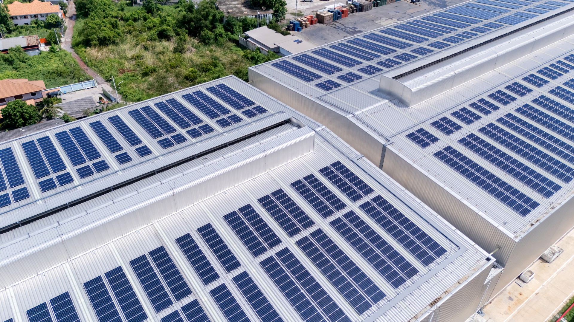 Numerous solar cells installed on the roof of a warehouse or factory, highlighting a commitment to reducing energy use through alternative energy solutions. This modern approach not only preserves the environment but also earns carbon credits.